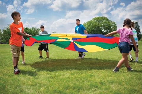 Children playing with a parachute outside